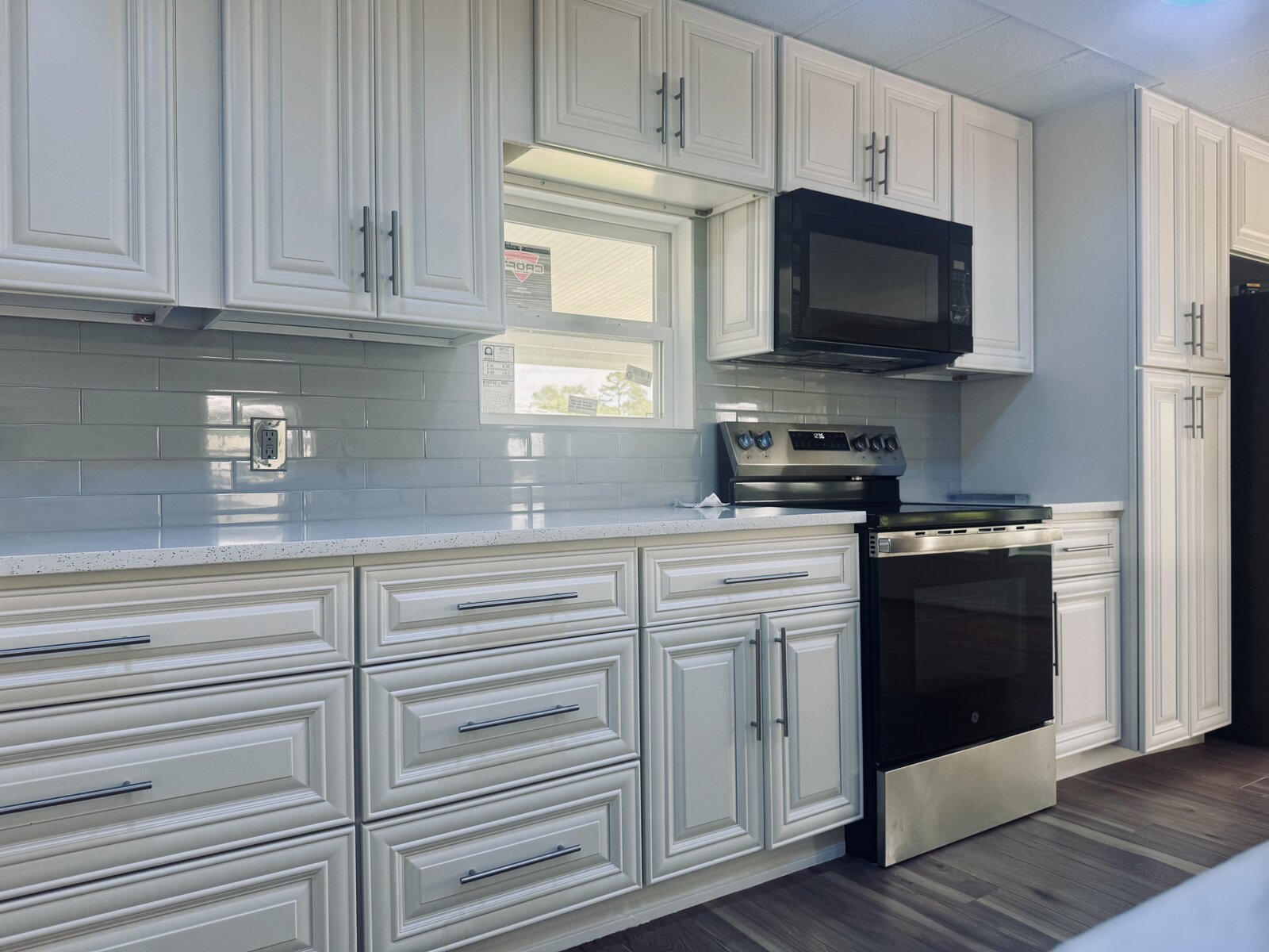 Renovated kitchen with white cabinetry and stainless appliances in a manufactured home